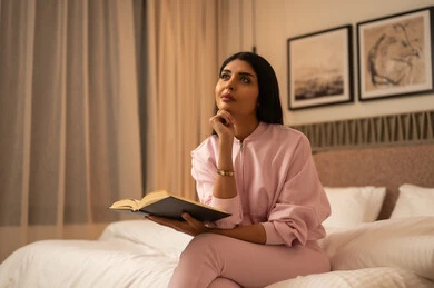 Saudi Woman Reading Book in Bedroom at Night