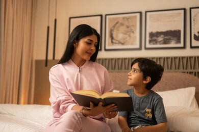Woman Reading Storybook to Child in Modern Bedroom