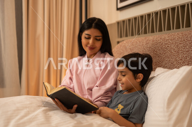 Arab Mother Reading Storybook to Child at Bedtime