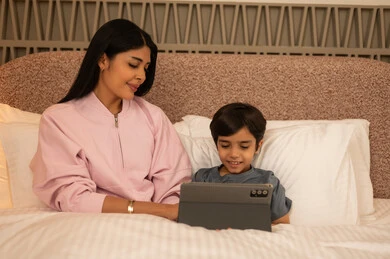 Arab Mother and Son Using Tablet in Bedroom