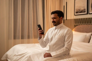 Saudi Man Using Smartphone in Modern Bedroom at Night