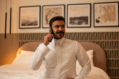 Arab Man in White Thobe Talking on Smartphone in Hotel