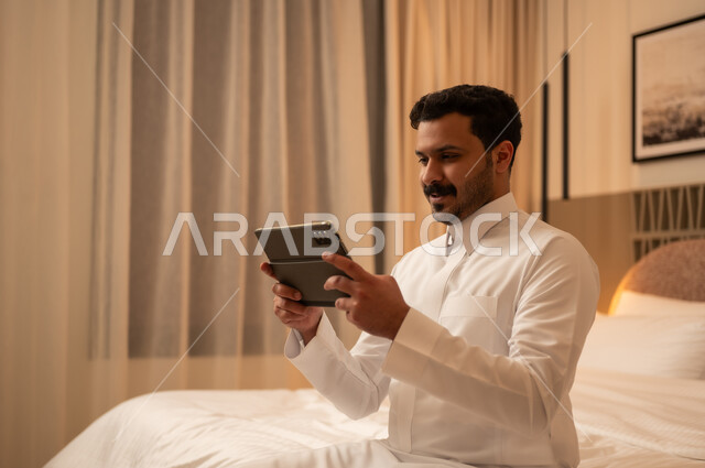 Arab Man Using Tablet in Hotel Bedroom