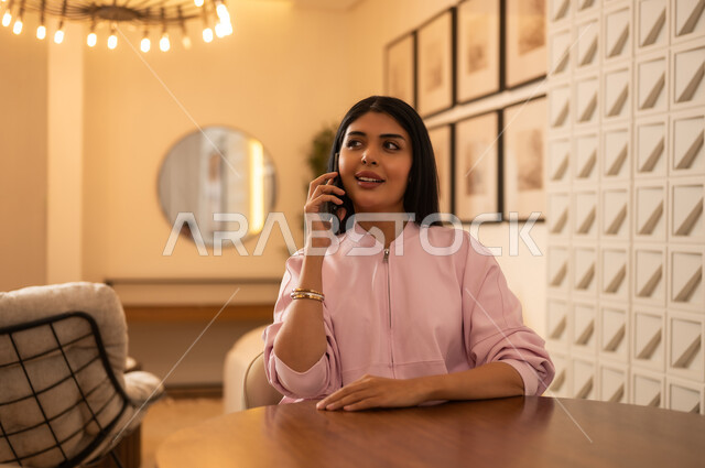 امرأة سعودية تتحدث عبر الهاتف في ديكور عصري