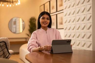 امرأة تستخدم جهازاً لوحياً في تصميم داخلي حديث