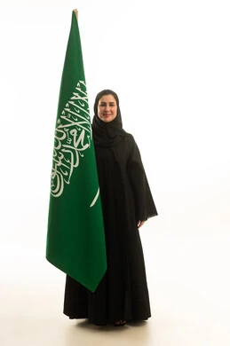 امرأة سعودية مع العلم الوطني بخلفية بيضاء