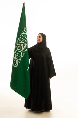 امرأة سعودية بالعباءة مع العلم على خلفية بيضاء