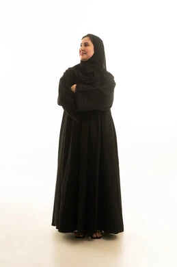 امرأة سعودية بالعباءة السوداء على خلفية بيضاء