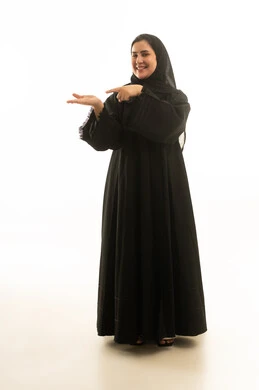 امرأة سعودية بالعباءة السوداء تشير إلى يدها