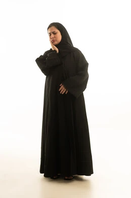 امرأة سعودية بالعباءة تعاني من ألم الأسنان بخلفية بيضاء