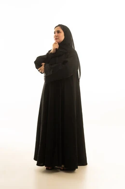 امرأة سعودية بالعباية السوداء تفكر بخلفية بيضاء