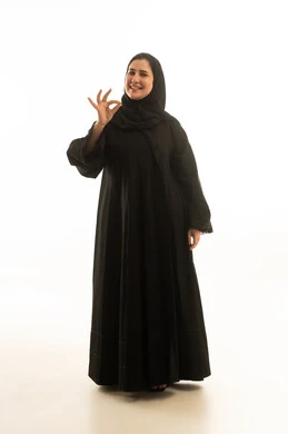 امرأة سعودية بالعباءة السوداء تشير بعلامة الموافقة