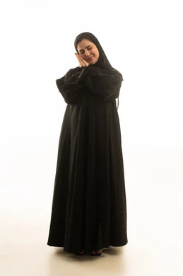 امرأة سعودية بالعباءة تقوم بحركة النوم على خلفية بيضاء