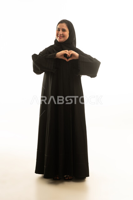 Smiling Saudi Woman Making Heart Gesture in Black Abaya