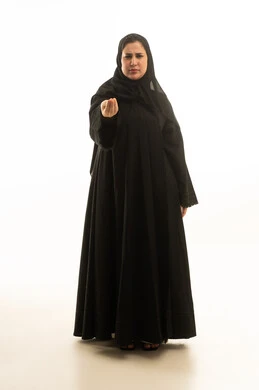 امرأة سعودية بالعباءة تقوم بإيماءة التمهل والانتظار