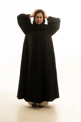 امرأة سعودية بالعباءة السوداء تشعر بالصداع والتوتر