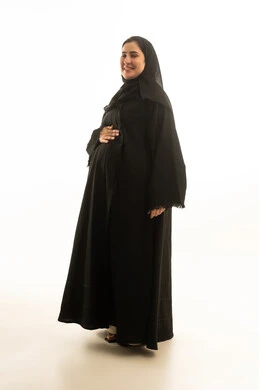 امرأة سعودية حامل بالعباءة السوداء في الاستوديو