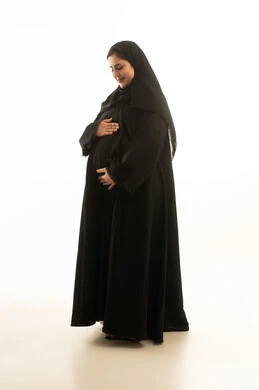 امرأة سعودية حامل بالعباءة السوداء بخلفية بيضاء