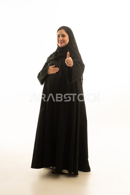 امرأة سعودية حامل بالعباءة ترفع إبهامها