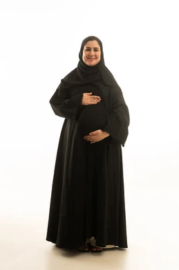 امرأة سعودية حامل بالعباءة السوداء على خلفية بيضاء