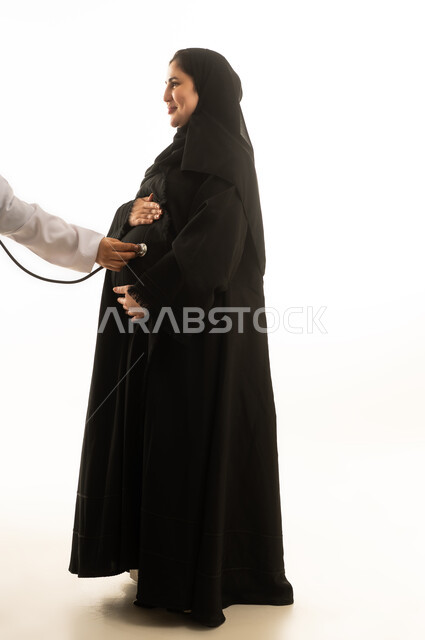 فحص طبي لامرأة سعودية حامل بخلفية بيضاء
