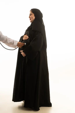 فحص طبي لامرأة سعودية حامل بخلفية بيضاء