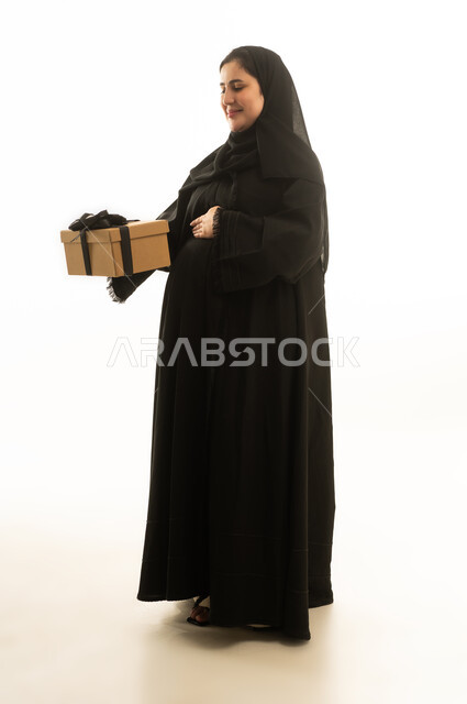 Pregnant Saudi Woman in Black Abaya Holding Gift