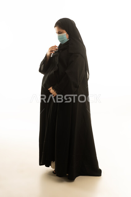 امرأة سعودية حامل بالكمامة أمام خلفية بيضاء