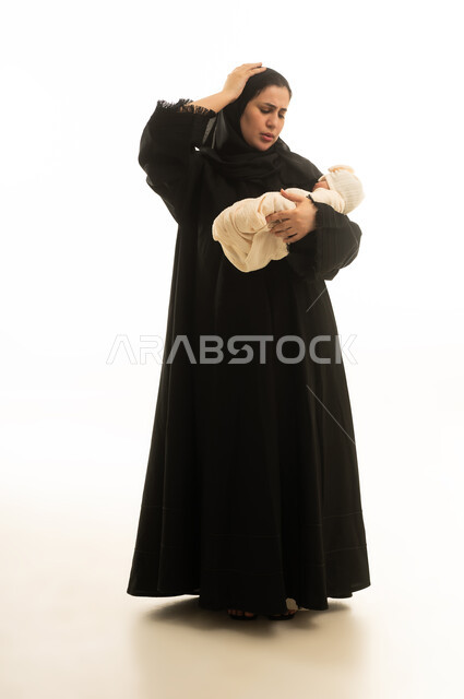 أم إماراتية بالعباءة السوداء تحمل طفلها الرضيع بتعب