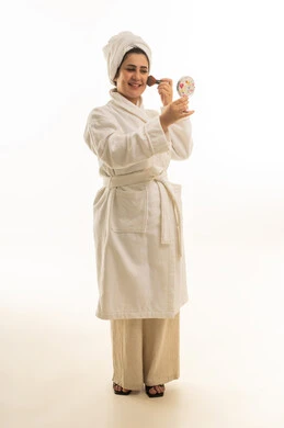 امرأة سعودية برداء حمام أبيض تضع المكياج