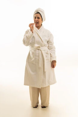 امرأة عربية برداء استحمام تأكل وجبة خفيفة