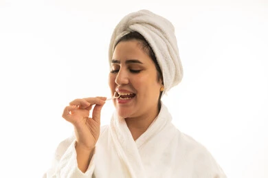 امرأة سعودية تستخدم خيط الأسنان برداء حمام أبيض في الاستوديو امرأة سعودية تستخدم خيط الأسنان برداء حمام أبيض في الاستوديو