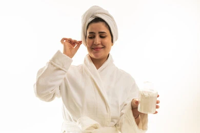 امرأة سعودية برداء حمام أبيض مع بودرة العناية بالبشرة