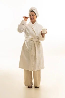 امرأة عربية برداء الحمام الأبيض مع منتج عناية