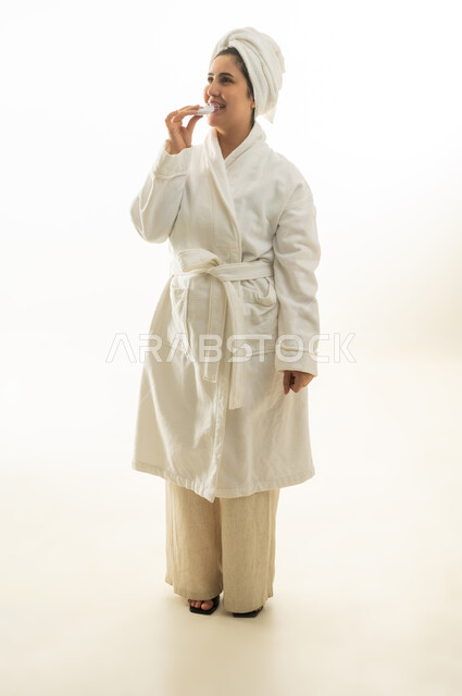 امرأة عربية برداء الحمام الأبيض تضع مرطب شفاه