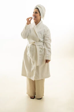 امرأة عربية برداء الحمام الأبيض تضع مرطب شفاه