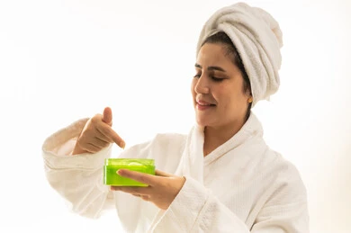 امرأة عربية برداء الحمام وتستخدم كريم العناية