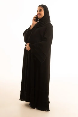 Saudi Woman in Abaya Talking on Smartphone White Background