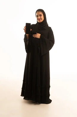 امرأة سعودية حامل مع هاتف ذكي بخلفية بيضاء