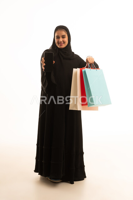 Saudi Woman with Shopping Bags and Smartphone