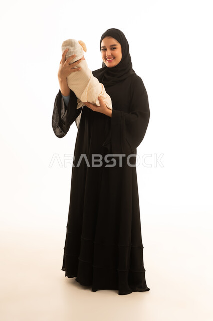 أم سعودية تحمل طفلاً حديث الولادة في الاستوديو