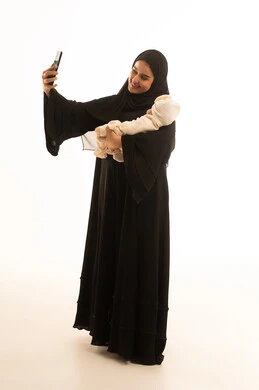 امرأة سعودية تلتقط سيلفي مع طفلها الرضيع في الاستوديو