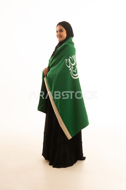 امرأة سعودية بالعباءة مع العلم الوطني على خلفية بيضاء