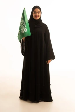 امرأة سعودية تحمل العلم السعودي بخلفية بيضاء