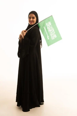 امرأة سعودية تحمل علم السعودية على خلفية بيضاء