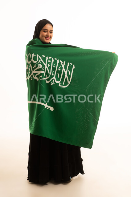 امرأة سعودية تحمل العلم الوطني على خلفية بيضاء