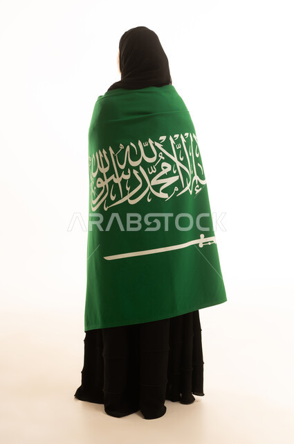 امرأة سعودية مع العلم الوطني على خلفية بيضاء