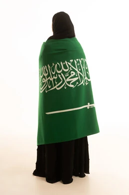 امرأة سعودية مع العلم الوطني على خلفية بيضاء