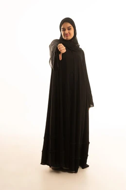 امرأة سعودية بالعباءة السوداء تقوم بإيماءة الرفض