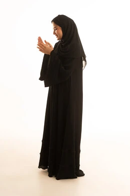 امرأة سعودية بالعباءة السوداء تدعو خلفية بيضاء